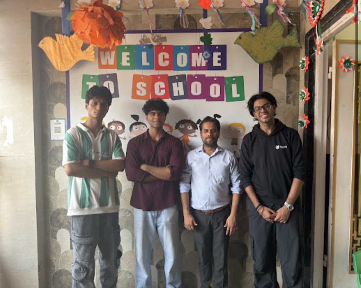 The Nacht mentors standing together in front of a school welcome board